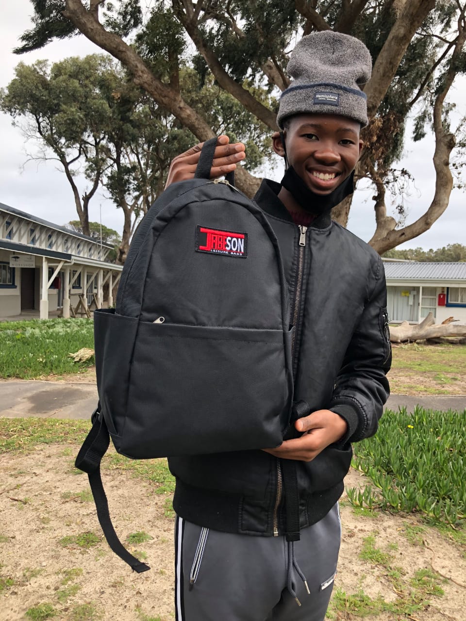 African Boy holding a bag smiling
